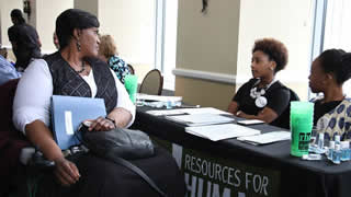 Academy student Paula Smith discussion job opportunities with Resources for Human Development representatives Julicia James and Taylor Thompson 