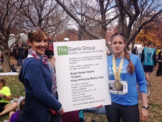 Janet Fiore & Kate Kelly holds a sign showing Team Academy sponsors