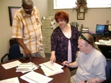 Marie Palladino working on a project with two students